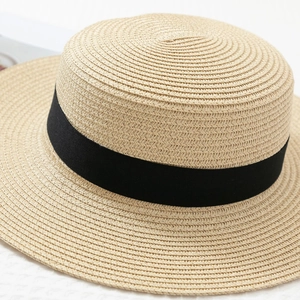 Detail shot of the fine straw weave texture and black ribbon on this flat top boater hat