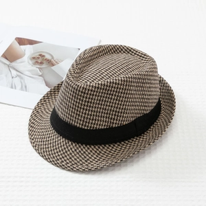 Detail of classic brown houndstooth fedora hat with elegant black decorative grosgrain ribbon