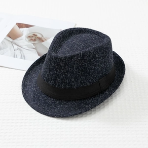 Detailed view of navy blue tweed fedora hat with black grosgrain ribbon on textured fabric