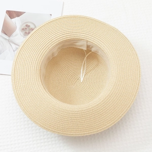 Detailed top view of beige straw sun hat with inner sweatband on waffle fabric