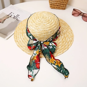 Close-up of a wide brim straw sun hat with a colorful floral ribbon and bow detail