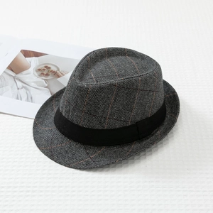 Detailed close-up of dark grey herringbone fedora hat with black ribbon on fabric