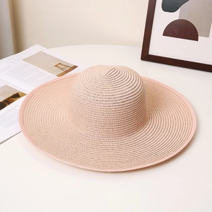 Close-up of the woven texture on a lotus pink wide-brim straw sun hat for women