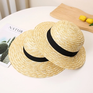 Set of two minimalist wheat straw hats with black ribbons for beach and summer vacations