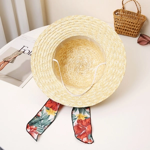 Detailed weave of straw beach hat featuring floral ribbon and elastic windproof strap