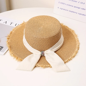 Elegant wide brim straw sun hat with frayed edges and pearl ribbon bow for summer beach