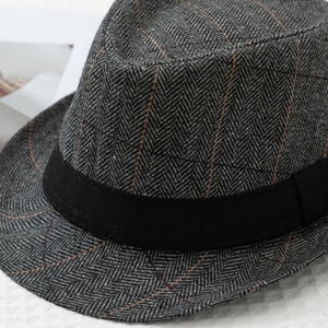 Detail of grey herringbone wool fedora featuring subtle orange windowpane check patterns