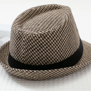 Close-up of classic houndstooth pattern fabric and black decorative band on fedora hat