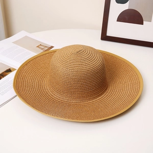 Detailed view of dark brown wide-brim straw hat with reinforced trim and spiral weave texture