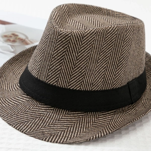 Detailed macro view of the herringbone weave pattern and black ribbon on a fedora hat