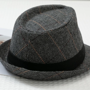 Detail of grey herringbone fedora hat with orange windowpane pattern and black band