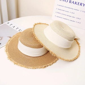 Flat top straw sun hats with white ribbons and frayed edges for summer beach vacation