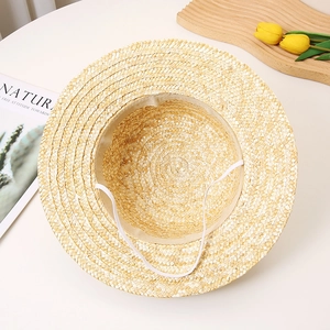 Detail view of straw hat interior showing beige sweatband and elastic chin strap texture