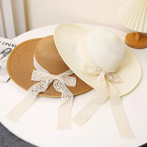 Women's wide brim straw sun hat with white lace ribbon bow in khaki and beige tones