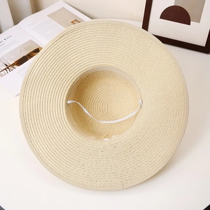 Detail of hand-woven beige straw hat interior showing dense texture and windproof rope