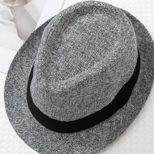 Close-up of grey wool blend fedora texture with black grosgrain ribbon on white background