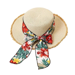 Straw sun hat with flat top and tropical floral ribbon bow for summer beach vacation