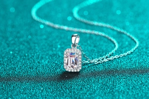 Macro view of emerald-cut gemstone necklace with halo sparkling round diamonds