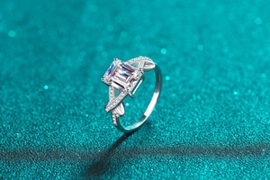 Macro shot of 3-carat emerald cut moissanite ring with pave set crisscross silver band