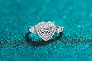 Macro detail of heart-shaped moissanite ring with double halo and tapered side diamonds