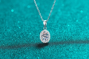 Vue macro d'un collier pendentif ovale en moissanite sur fond scintillant bleu