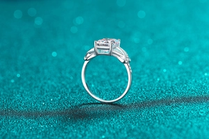 Macro detail of 3 carat emerald-cut moissanite ring with pavé stones and twisted band