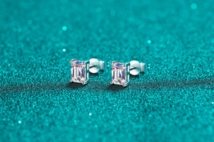 Macro shot of emerald cut moissanite stud earrings in a classic four-prong silver setting