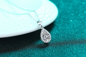 Macro shot of S925 sterling silver pear-shaped moissanite necklace with halo pendant