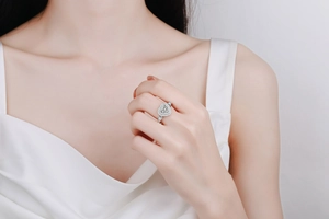 Detail of S925 sterling silver ring with heart-cut moissanite stone on a model's finger