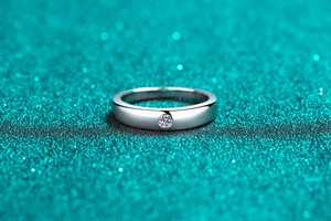 Macro shot of silver moissanite ring with brilliant round cut stone and polished finish