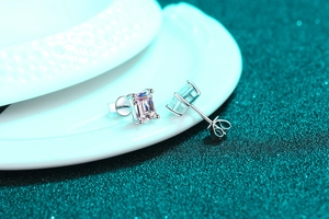 Macro shot of silver stud earring featuring an emerald-cut moissanite stone in a 4-prong setting