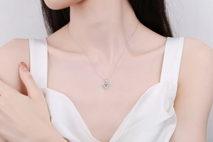 Detail of S925 sterling silver necklace featuring a triangular Moissanite pendant on a model