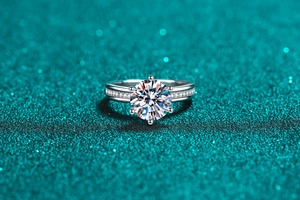 Macro shot of 3ct round moissanite engagement ring with six-prong setting and side diamonds
