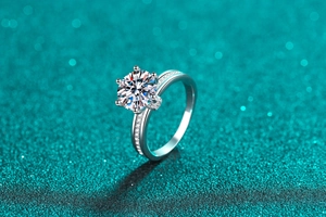 Macro shot of a classic six-prong moissanite ring with micro-pave diamonds on silver band