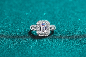 Macro shot of S925 sterling silver ring featuring emerald cut center stone and halo setting