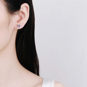 Close-up of minimalist S925 sterling silver four-prong solitaire stud earring on model