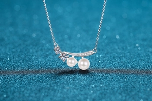 Detail of S925 silver necklace featuring two freshwater pearls and three moissanite stones