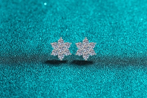 Macro detail of S925 sterling silver sunflower stud earrings with shiny moissanite stones