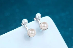 Detailed view of S925 silver double pearl jacket earrings with sparkling zirconia halo