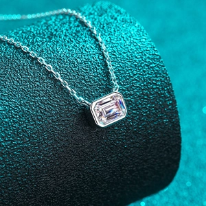 S925 sterling silver necklace featuring an emerald cut moissanite pendant on a black prop