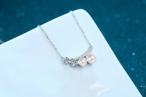 Macro shot of S925 silver necklace with two freshwater pearls and sparkling moissanite