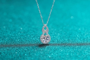 Close-up of S925 silver gourd necklace with moissanite stones on a blue background