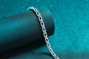 Détail macro du bracelet tennis en argent avec pierres roses et entourage de zircons