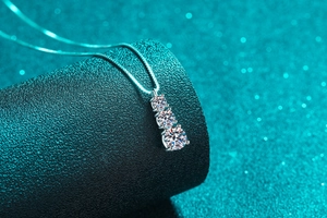 Gros plan d'un collier en argent 925 avec trois moissanites de tailles graduées