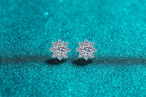 Macro detail of S925 sterling silver snowflake stud earrings with sparkling moissanite stones