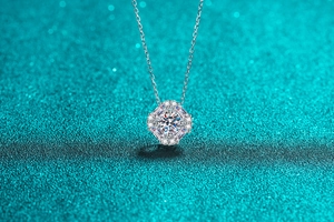 Macro shot of S925 sterling silver necklace featuring a moissanite pendant on blue background