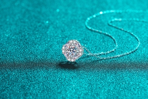 Macro shot of S925 silver necklace with octagon moissanite pendant on teal background