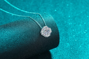 Macro detail of S925 silver necklace with hexagonal moissanite pendant on luxury display