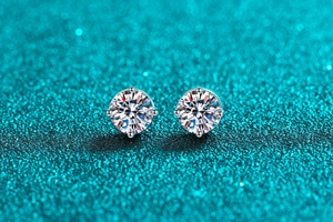 Macro view of round brilliant cut moissanite earrings with a four-prong silver setting