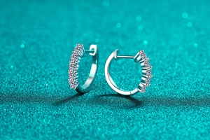 Makroaufnahme von Creolen aus S925 Sterlingsilber mit kleinen Moissanit-Steinen in Reihe